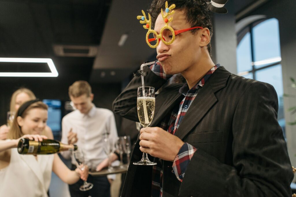 Office party with playful costumes, champagne, and joyful people gathering.